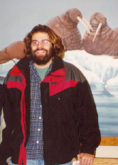 Photograph of Jason standing in front of a mural at Fairbanks International Airport.
