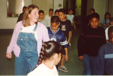This is a photograph of Amanda teaching "The Slap Leather" line dance to fourth grade students at Roskruge Elementary.  