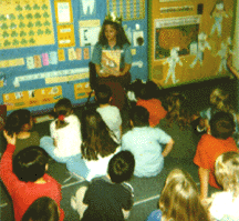 The photograph shows Amber sharing the book with students.